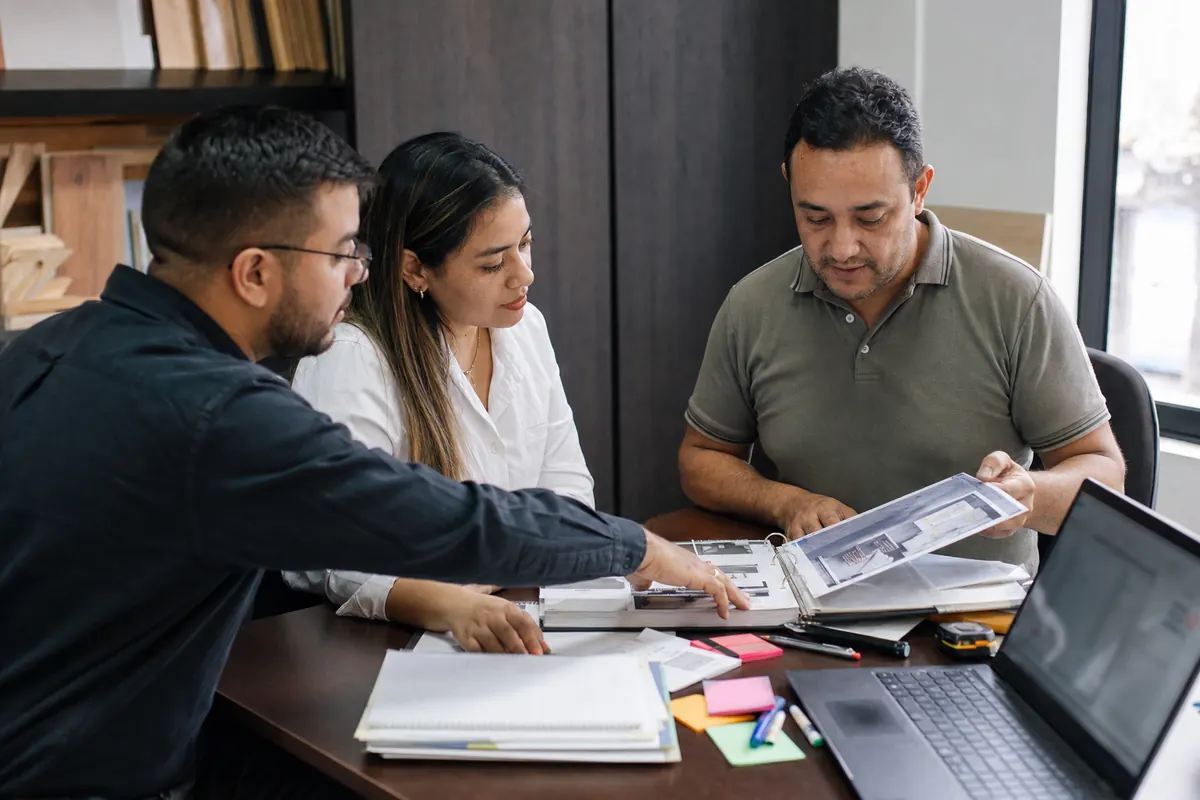 Consultants review the catalog and price list with a store owner to train the assistant